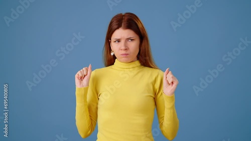 Mad woman screams gesticulating to reduce stress on blue photo