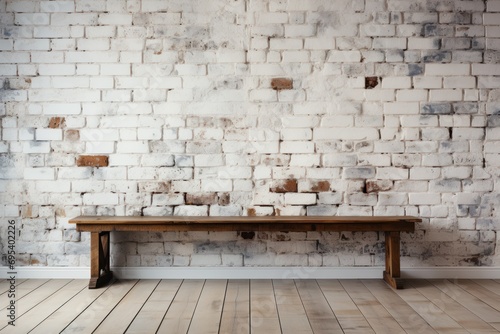  a wooden bench against a brick wall in a room with hard wood flooring and a white painted brick wall with a wooden bench in the middle of the floor. © Nadia