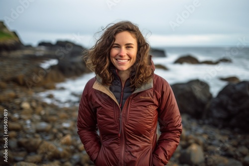Portrait of a joyful woman in her 30s sporting a quilted insulated jacket against a peaceful tide pool background. AI Generation © Markus Schröder