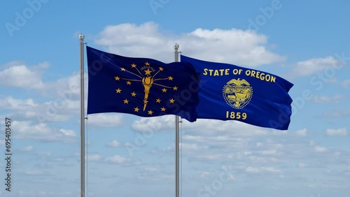 Oregon and Indiana US state flags waving together on cloudy sky, endless seamless loop photo