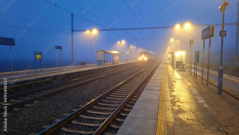 Night railway terminal. Deserted train station in fog. Concept of travelling, tourism or commuting to work