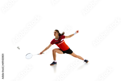 Intensity of championship preparation. Badminton athlete demonstrates her skills in attack and defense against white background. Concept of sport, active lifestyle, strength, power, action. Copy space