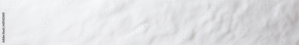 a close up of a bed with a white comforter and a black and white clock on the side of the bed and a black and white pillow on the side of the bed. a close up of a bed with a white comforter and a black and white clock on the side of the bed and a black and white pillow on the side of the bed.