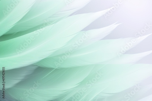  a close - up of a green feather on a white and grey background with a blurry image of the back side of the feathers of a bird's head. © Nadia