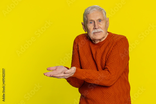 Senior old man raising hands asking what why reason of failure, demonstrating irritation by troubles trendy social media meme anti lifehacks ridicules people who complicate simple tasks for no reason photo