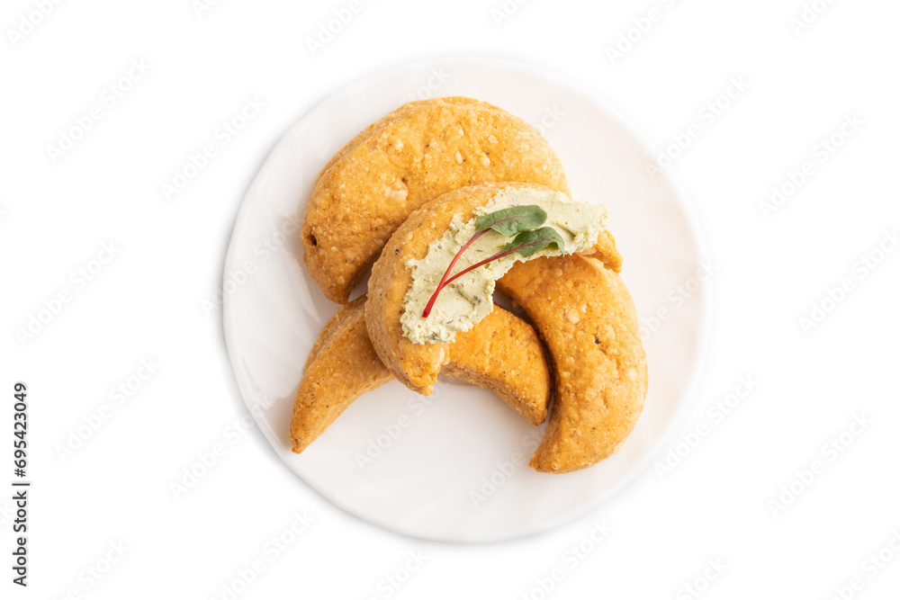 Homemade salted crescent-shaped cheese cookies isolated on white. top view.