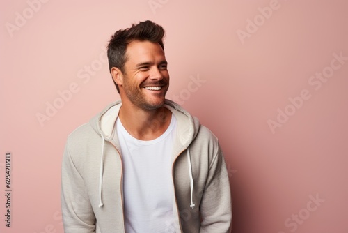Portrait of a happy man in his 30s wearing a zip-up fleece hoodie against a pastel or soft colors background. AI Generation