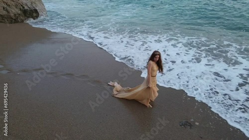 Young beautiful woman fallen angel stands on sea beach enjoy nature. costume bird white wings.