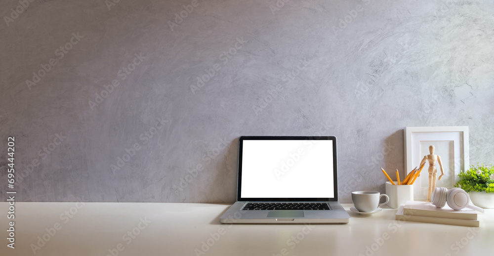 Laptop computer with empty screen, stationery and potted plant on white table in bright office. Laptop computer with empty screen, stationery and potted plant on white table in bright office.