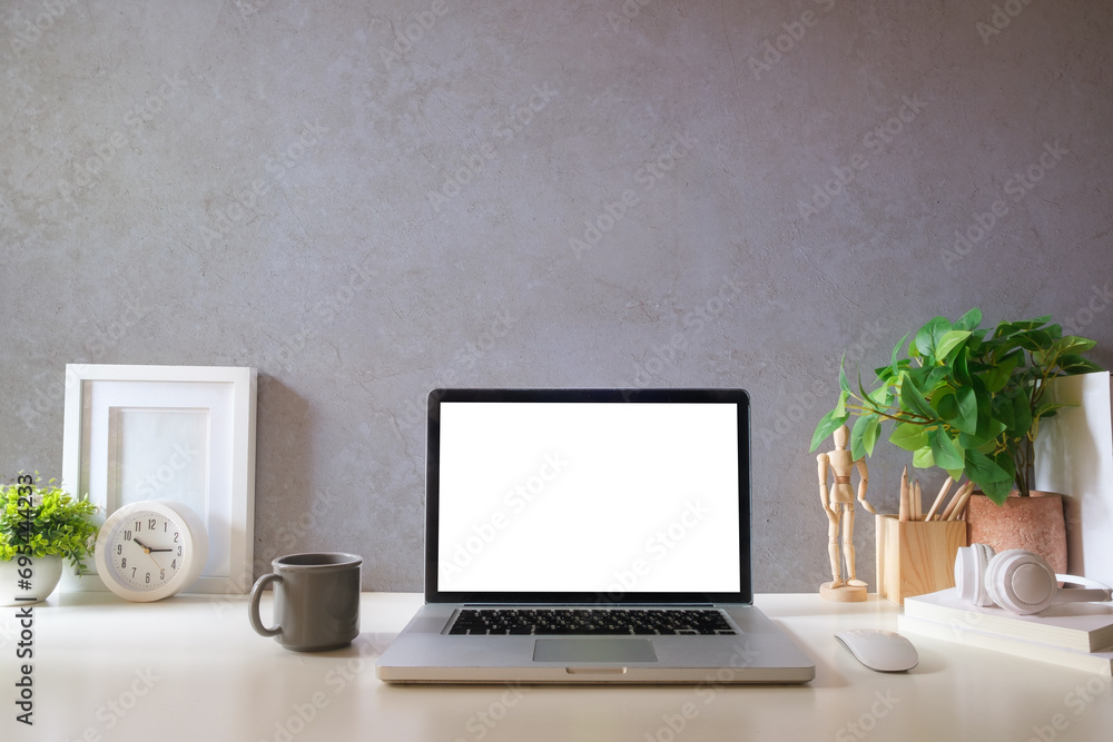 Comfortable home office. Laptop computer, stationery and potted plant on white table. Comfortable home office. Laptop computer, stationery and potted plant on white table.