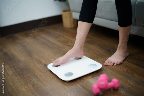Fat diet and scale feet standing on electronic scales for weight control. Measurement instrument in kilogram for a diet control photo