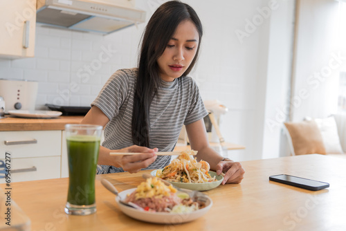 Asian Girl   eating Thai food in kitchen counter Home delivery food feeling happy  