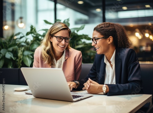 business woman looking at linux laptop with her colleagues in a modern, in the style of light white and light gold, afro-caribbean influence, photo taken with nikon d750, polished concrete, american b photo