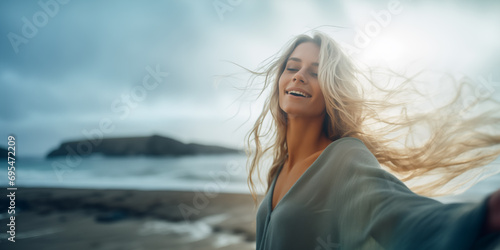 wide shot Happy blonde woman, outdoor freedom and arms outstretched,, ocean wind and breathe fresh air, taking selfie shot, motivation and wellness, peace and hope.