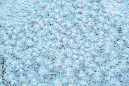 blue background of frosty patterns of ice and snow on a winter river