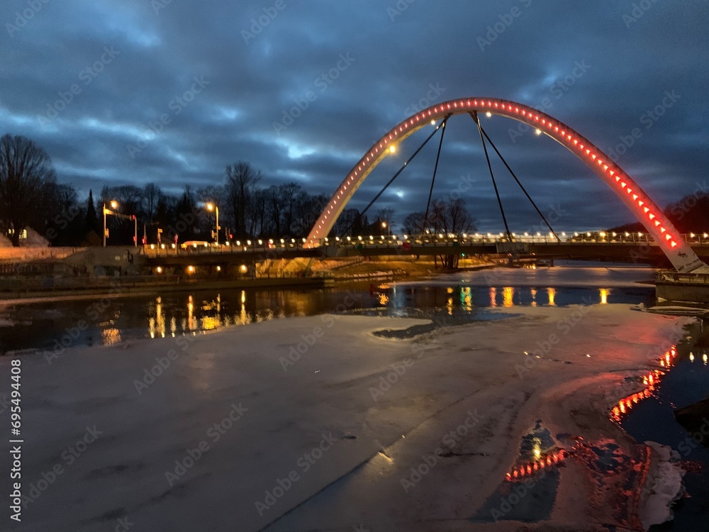 Obraz premium Vabadussild bridge over frozen Emajõgi river at night in Tartu, Tartumaa, Estonia, February 2021