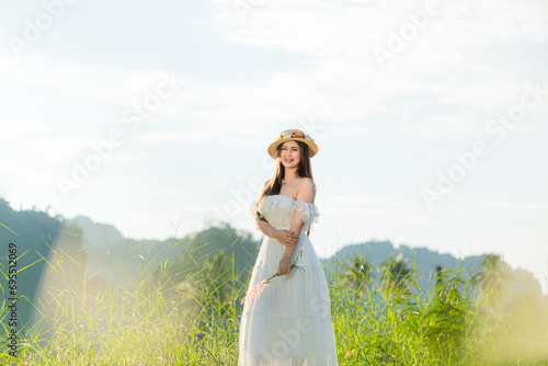 Asian woman in white dress skirt on nature background,Young woman traveler wear hat on nature background, mtravel concept  photo