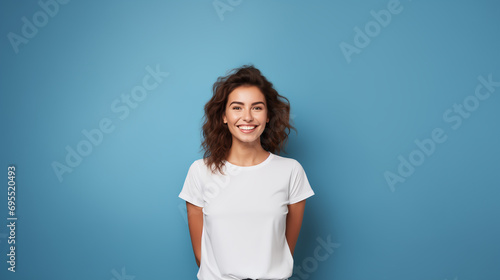 portrait of a smiling woman wearing a white t-shirt isolated on a blue, bright blue background