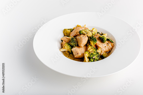 Vindaloo with spinach in white bowl isolated on white background. Portuguese Influenced Indian dish made by cooking chicken in vindaloo spice paste and broccolli.