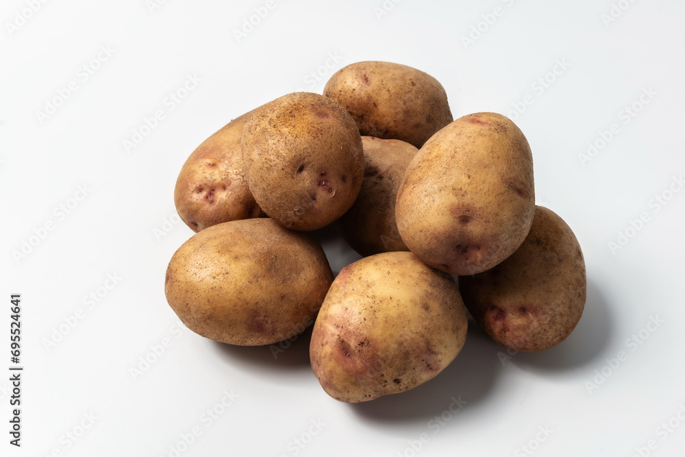 Raw potatoes isolated on a white background. A popular vegetable. An essential product for cooking Raw potatoes isolated on a white background. A popular vegetable. An essential product for cooking
