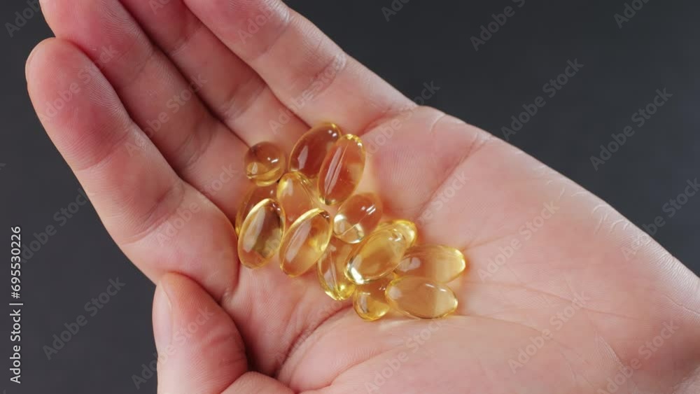 Omega fish oil gel capsules on man hand close-up . Human keeps in hands Omega vitamins pills 3 6 9. To be healthy and take care of your health. Pharmaceutical Omega fish oil gel capsules on man hand close-up . Human keeps in hands Omega vitamins pills 3 6 9. To be healthy and take care of your health. Pharmaceutical