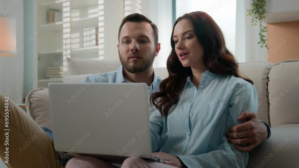 Happy young couple using laptop for ecommerce doing online shopping with shop app together at home Caucasian man and woman looking at computer buying searching in internet booking trip tickets choose Happy young couple using laptop for ecommerce doing online shopping with shop app together at home Caucasian man and woman looking at computer buying searching in internet booking trip tickets choose