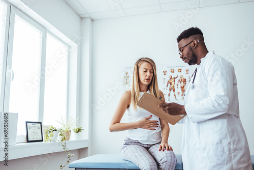 A woman in consultation with a doctor with abdominal pain. It is a painful menstrual period or bladder. And ectopic pregnancy. Immediate treatment immediately photo