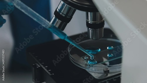 Young scientists conducting research investigations in a medical laboratory, a researcher in the foreground is using a microscope photo