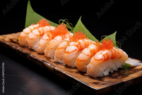  a wooden plate topped with sushi covered in sauce and garnished with green leafy garnishes on top of a black surface with a black background.