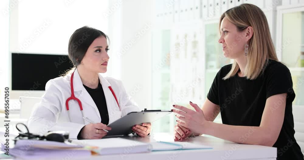 Woman patient talks about health problems to doctor Woman patient talks about health problems to doctor