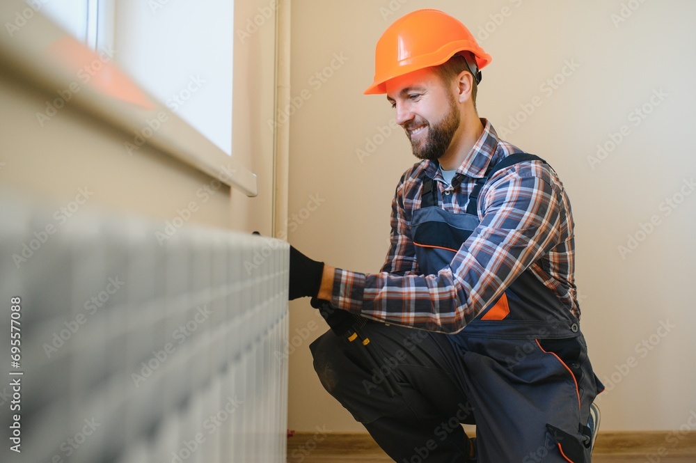 Plumber man is blocking repairs radiators of heating battery in apartment tap Plumber man is blocking repairs radiators of heating battery in apartment tap