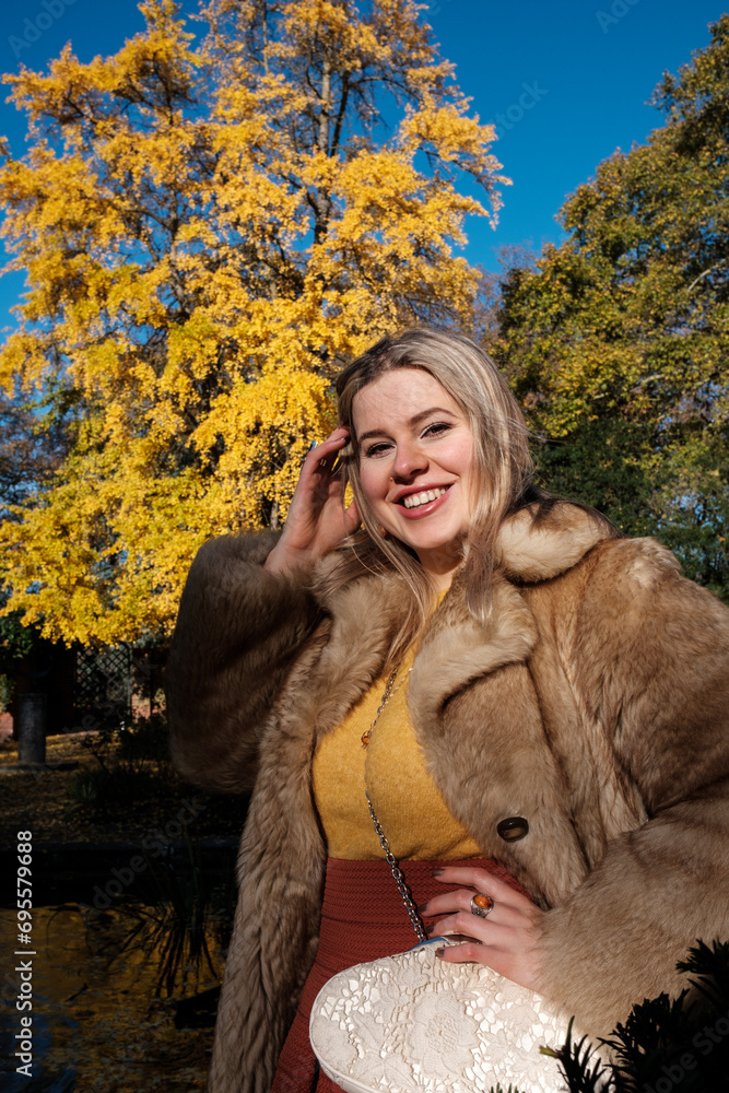 Smiling of friendly young woman posing in an autumn park. Smiling of friendly young woman posing in an autumn park.