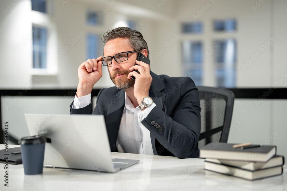 Business man talking on phone at office workplace. Occupation person in work space. Business portrait. Confident business worker. Business, finance and employment. Successful office worker. Business man talking on phone at office workplace. Occupation person in work space. Business portrait. Confident business worker. Business, finance and employment. Successful office worker.
