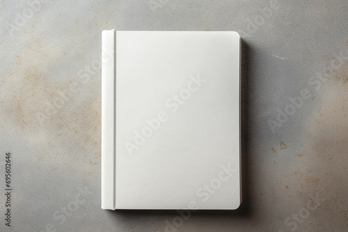 A blank hardcover book mockup with a matte finish, lying flat on a textured linen surface. photo