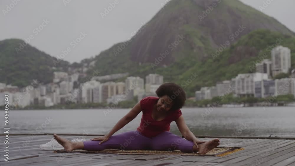 Middle-aged woman stretching, practicing yoga, sitting on a pier on the waterfront. Cinematic 4k. Middle-aged woman stretching, practicing yoga, sitting on a pier on the waterfront. Cinematic 4k.