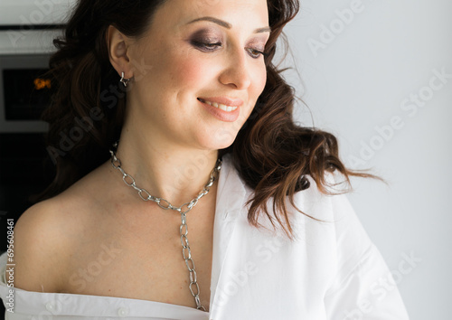 Close-up woman wears massive chain on neck, metal necklace. Modern jewellery concept photo