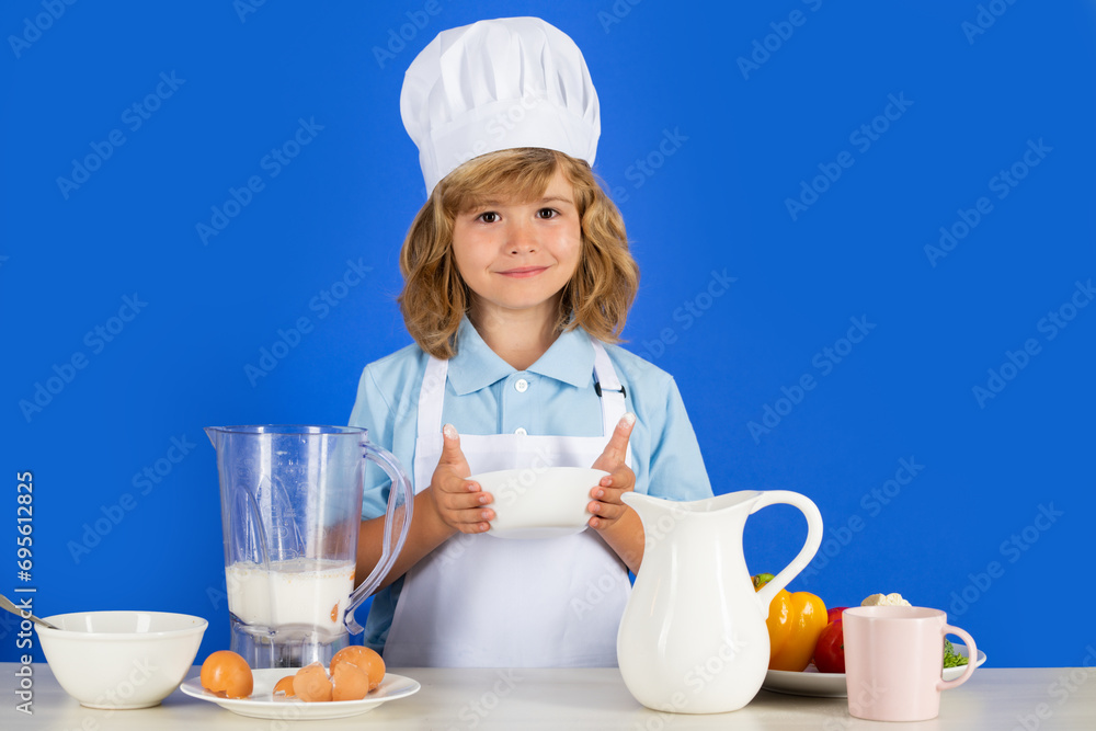 Cooking children. Chef kid boy making fresh vegetables for healthy eat. Portrait of little child in form of cook isolated on blue background. Kid chef. Cooking process. Cooking children. Chef kid boy making fresh vegetables for healthy eat. Portrait of little child in form of cook isolated on blue background. Kid chef. Cooking process.