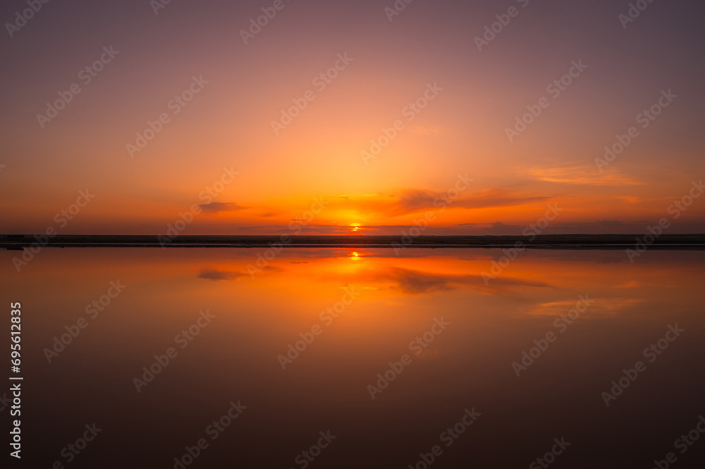 Sunset or sunrise sky. Clouds over water. Golden Dawn. Dramatic coast nature background. Beautiful sea beach at sunset. Morning shoreline sunlight.	

