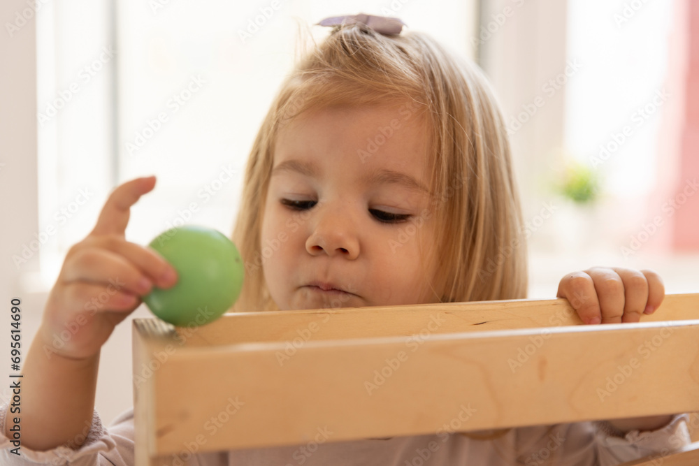 Toddler girl playing with the gravity wooden ball toy Toddler girl playing with the gravity wooden ball toy