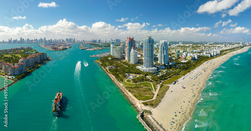 View from above of big container ship entering main channel in Miami harbor near South Beach high luxurious hotels and apartment buildings © bilanol