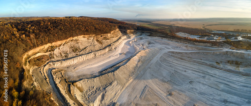 Aerial view of open pit mining site of limestone materials for construction industry with excavators and dump trucks photo