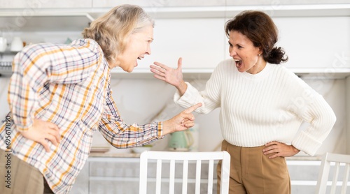 Domestic quarrel - an elderly mother quarrels with her adult daughter and starts screaming photo