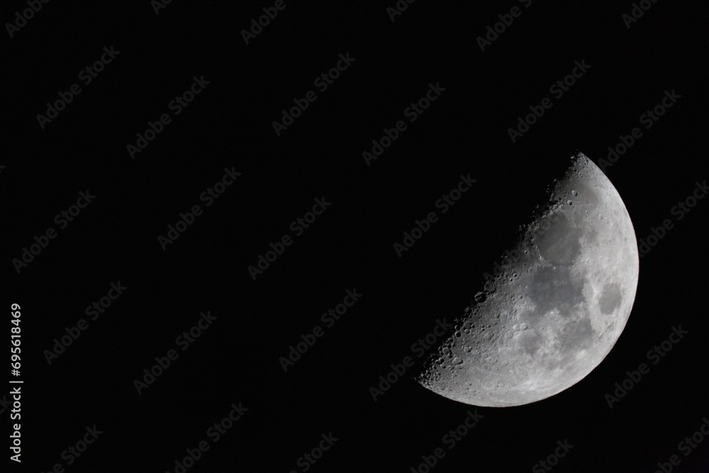 crescent moon photographed with a telescope. The moon is at 50% luminosity