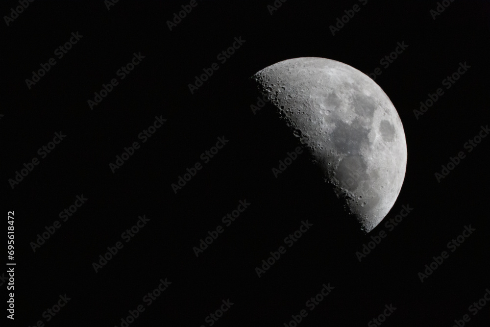 crescent moon photographed with a telescope. The moon is at 50% luminosity