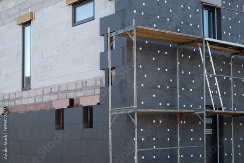 New House building in process insulation of the wall of the house with layers of modern thermal insulation materials . Exterior covering in construction site.