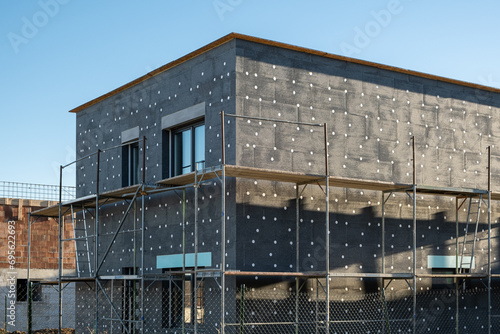 New House building in process insulation of the wall of the house with layers of modern thermal insulation materials . Exterior covering in construction site.