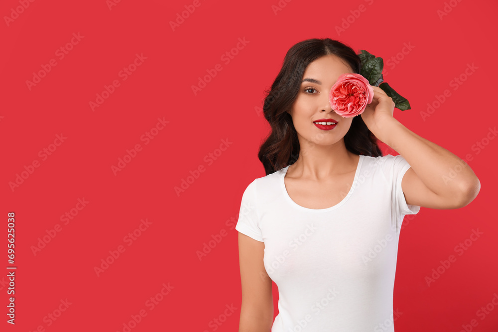 Young Asian woman with beautiful pink rose on red background Young Asian woman with beautiful pink rose on red background