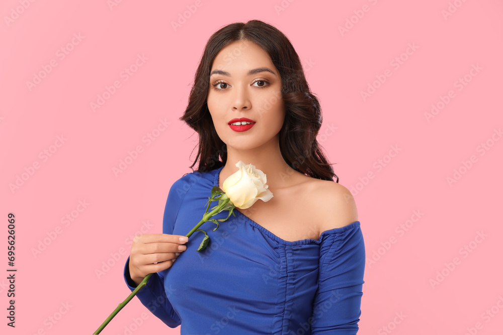 Young Asian woman with beautiful white rose on pink background Young Asian woman with beautiful white rose on pink background