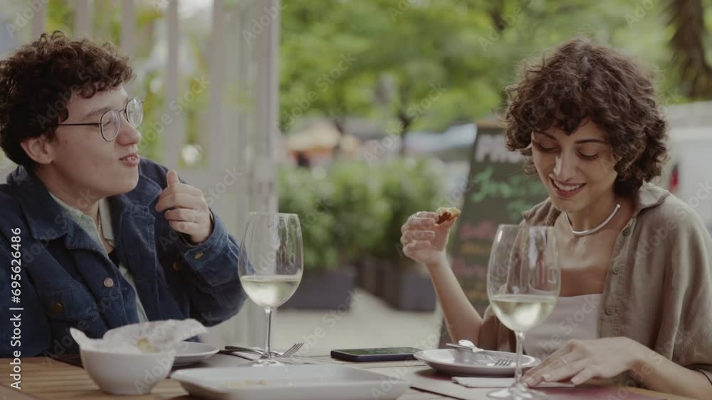 Couple of women eating and having fun during pleasant lunch in an open-air restaurant. Cinematic 4k. Couple of women eating and having fun during pleasant lunch in an open-air restaurant. Cinematic 4k.