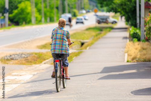 Wallpaper Mural A cyclist in the village, viewed from the back. Background with selective focus and copy space Torontodigital.ca
